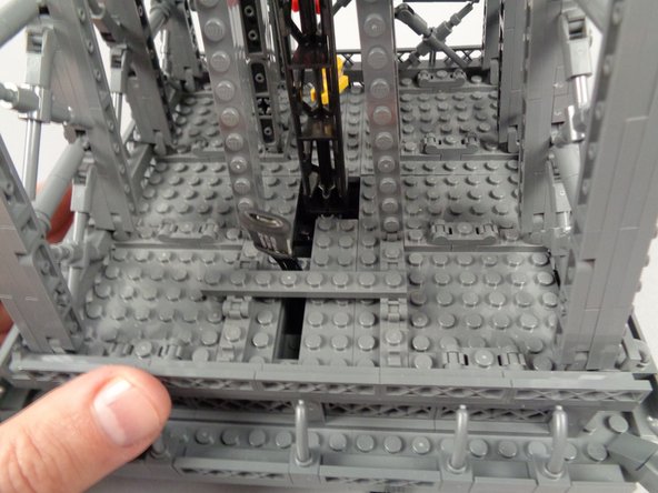 As shown in the photos for this step, replace the 1x8 plate you removed earlier, placing it sideways to hold the wire for the inter-level connecting board.