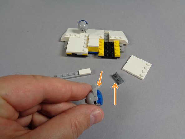 Take the front roof section, and as shown in the first photo for this step, remove the large white plate as well as the light bluish gray plate and the first blue light assembly.