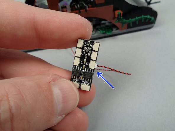 The second photo for this step shows the LED light wire pulled through to the back.