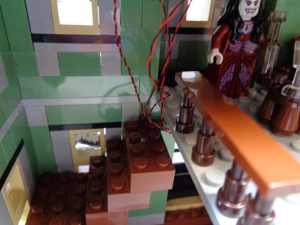 Each brick you re-attach should continue holding the fireplace light wires along the front wall.