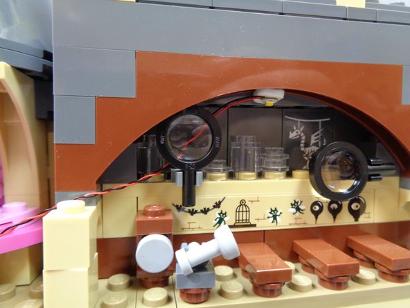 As shown in the second photo, attach the light to the center of the arch inside the Defense Against the Dark Arts classroom.