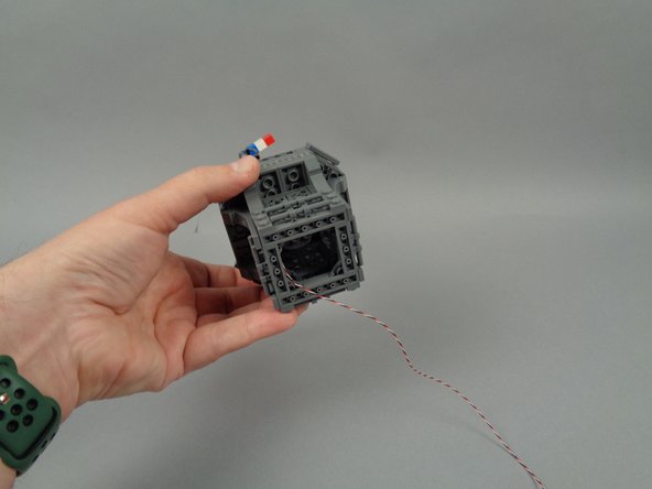 As shown in the third photo, you should have the control wire for the flexible LED light strip coming out of the bottom center of the tower.