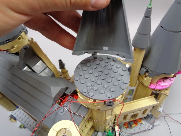 As shown in the first photo, re-attach the top front cone section of the tower.