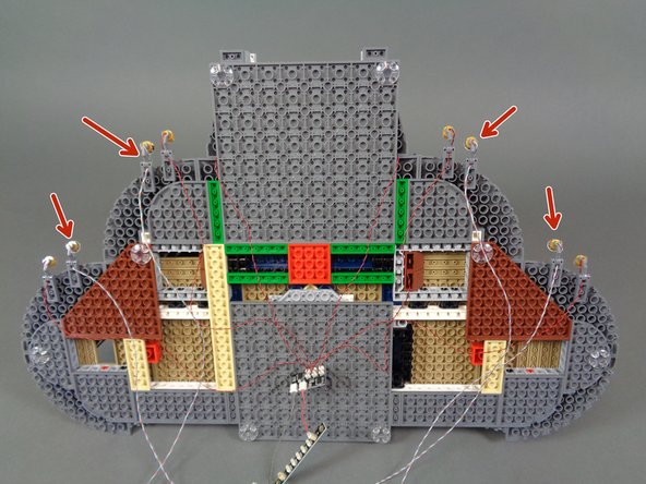 As shown in the second and third photos, remove four color-changing spotlights from the bag and mount them  along the castle base nest to the warm white spotlights (see the red arrows in the third photo).