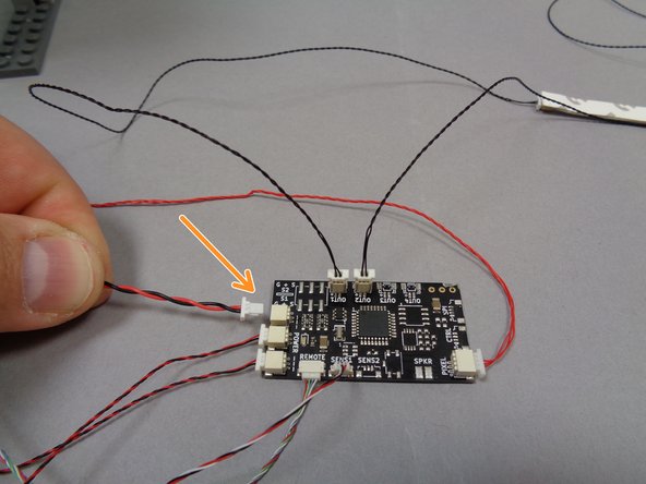 As shown by the orange arrow in the second photo, connect the plug from the USB power cable to the last open &quot;POWER&quot; connector on the TRUNK08 master controller.