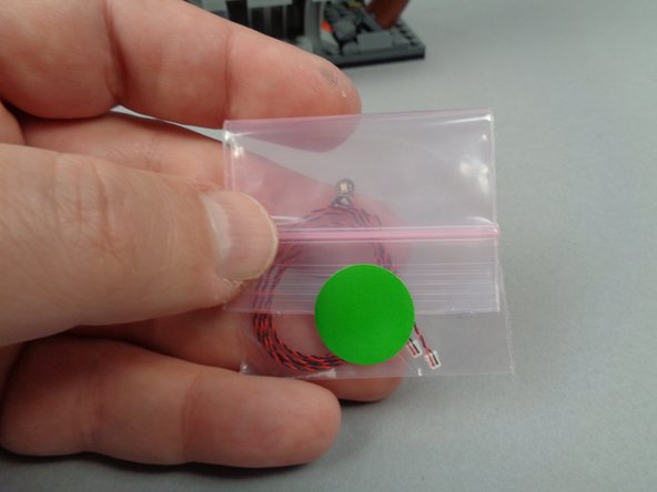 As shown in the first photo for this step, take the two green LED lights from the bag with the green dot.