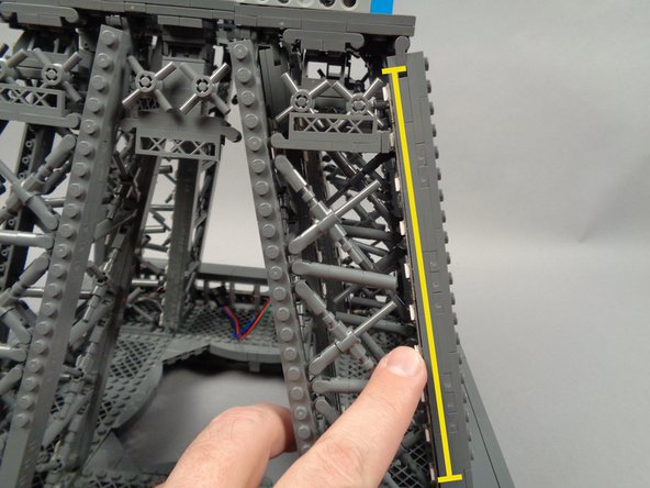 As shown in the second photo for this step, mount the second strip, pressing with two fingers to make sure it adheres firmly to the tower frame.