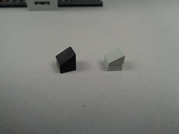 As shown in the two photos for this step, take four parts from the spares from your original LEGO set and create two angled mounts for two LED lights.