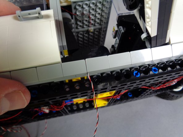 As shown in the third photo for this step, re-attach the slope to hold the wire in place.