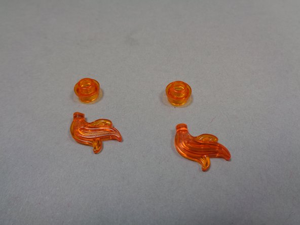 Inside Bag 10, there will be two transparent orange flames that have their bottom tips cut off. Remove the two flame parts from the fireplace and replace the flame tops with the two flames from your Brickstuff kit.