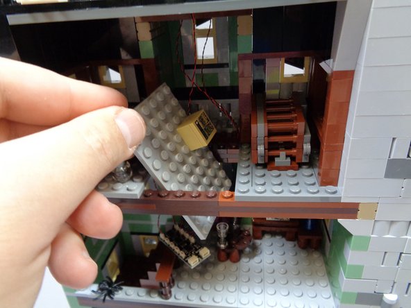 As shown in the second photo, carefully pass the attic floor section up from the second floor, and rest it in the attic as shown in the third photo.