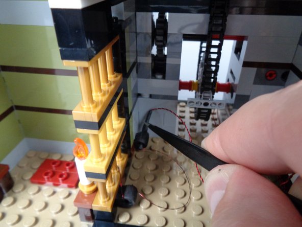 Be careful when passing the section of black tubing through the rubber parts.  If needed, use the tweezers to help push (not pull) the tubing through both rubber parts as shown in the third photo.