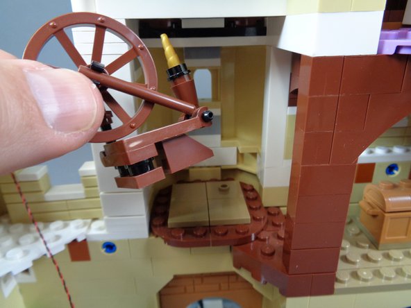 As shown in the photos for this step, remove the spinning wheel and floor sections in the room above the kitchen, then run the LED light wire toward the spinning room, lifting the white wall section to hold the wire in place.