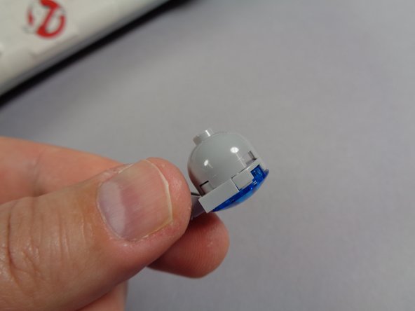 As shown in the photos for this step, finish re-assembling the hood spot light, taking care to make sure the light wire passes between the clip prongs and that the wire is not pinched when the light is re-attached to its bracket.