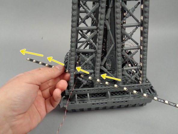 To prepare, feed the strips connected to plug #1 on the adapter board through the center of the next pillar as shown by the yellow arrows in the second photo.
