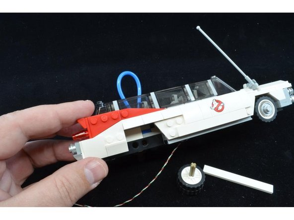 The wire coming from the front needs to be fed into the rear interior area of the Ecto-1.  Remove the right rear wheel and side panel as shown in the first photo.