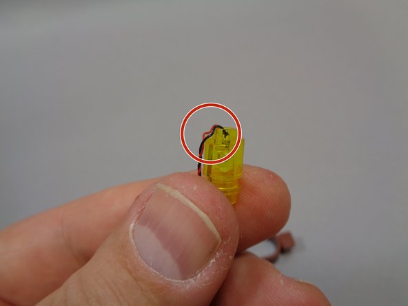 As shown by the red circle in the third photo, bend the light wire with your fingernail so it runs down the side of the stud on the bottom of the pre-lit lantern assembly.