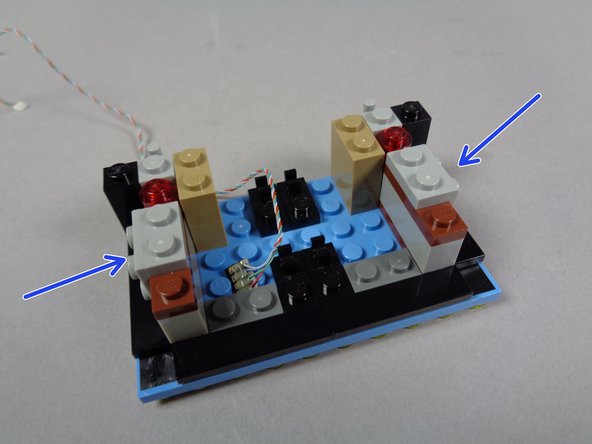 As shown by the two blue arrows in the first photo, re-attach the two inner side sections of the marquee base.