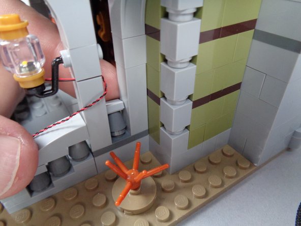 As shown in the third photo for this step, press the column back into position.  This should hold the light wire in place as shown.