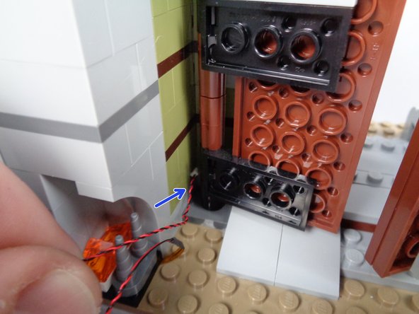 Next you will run the wire for the fireplace light up around the front door hinge and out through the front of the mansion above the window.