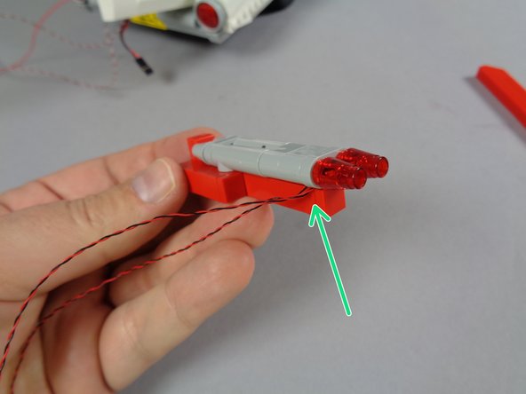 As shown by the green arrow in the second photo, make sure the wires for the two LED lights pass out the left side.