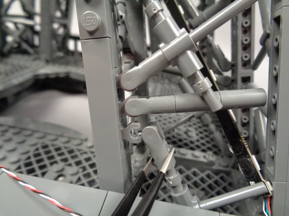 As shown in the first photo for this step, to make room for the control cable to pass, you need to temporarily disconnect the "X" crossbar at the bottom of the pillar.