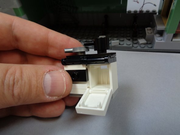 As shown in the photos for this step, remove the kitchen table and stove assembly.  Open the oven-- this is where you will mount the last orange light in the next step.