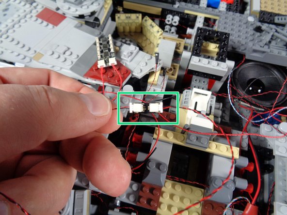 As you did with the first 4-light docking bay LED assembly, locate the single power wire from the 4-light assembly on the Falcon side opposite the boarding ramp.  This will be a wire with a large plug, as shown in the second photo.