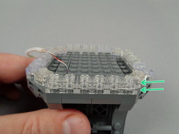 The green arrow in the third photo for this step shows the finished clear section, extending around the edge of the broadcast tower, now two plates in height.