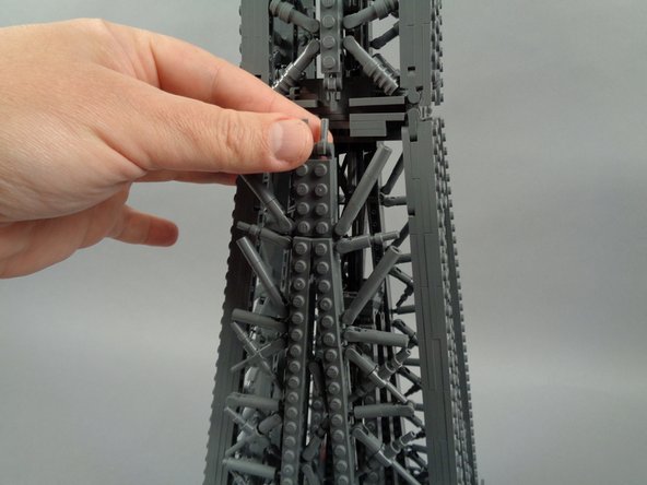 As shown in the second and third photos, use the tweezers to remove the two clips holding the top of the panel in place, then gently ease the panel toward you.