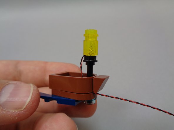 As shown in the second photo, re-attach the boat frame.  The frame will hold the LED power wire in place.