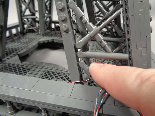 As shown in the third photo, re-attach the "X" crossbar with the control cable passing behind it.