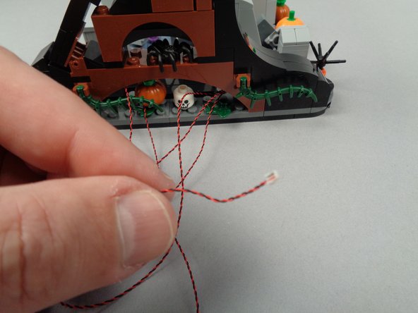 The second photo for this step shows the LED light wire pulled all the way through to the back.