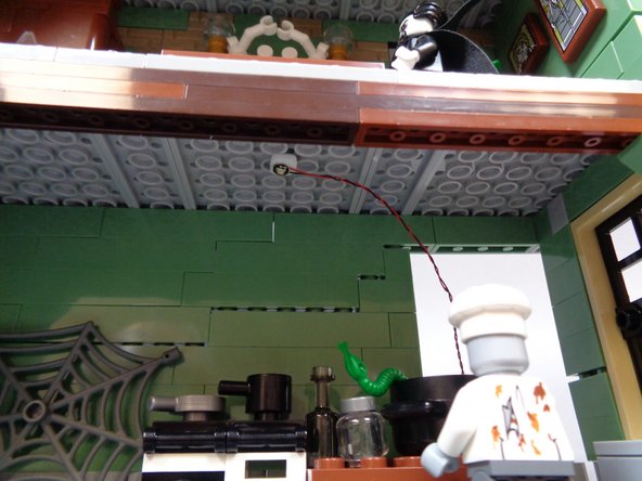 As shown in the third photo, mount the green Pico LED light on the kitchen ceiling above the stove.  The light wire should extend out the back of the kitchen wall.