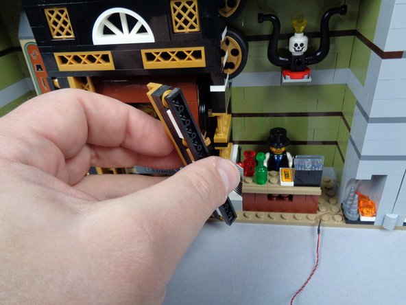 As shown in the three photos for this step, remove the two side brackets holding the elevator in place, then carefully remove the elevator car.  Set aside.