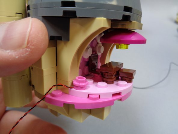 As shown in the second photo, your light should now be re-attached with the light wire extending out the left side of Umbridge's Office.