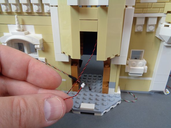 As shown in the second photo, pull the light wire out from the front of the castle.