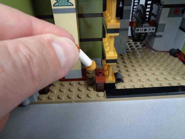 As shown in the photos for this step, remove the two candles from the obelisk room, and separate the candles from their gold plate bases.