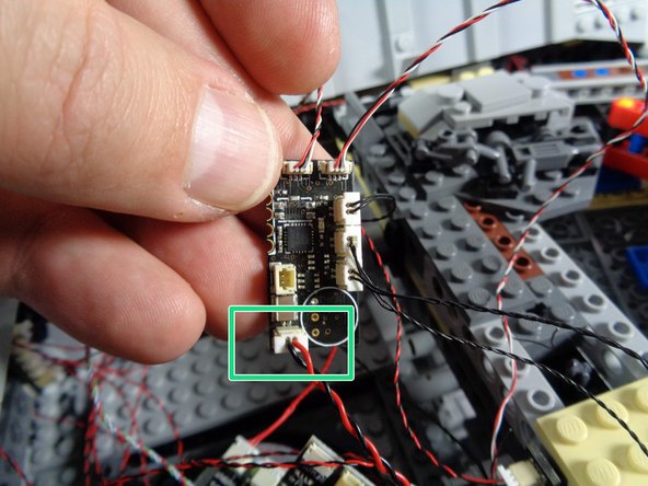 As shown by the green rectangles in the first and second photos, carefully disconnect the main power wire from the old TRUNK05 controller.