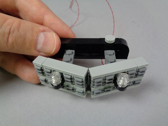 The two LED light wires should pass under the strobes and out the back side of the grille.
