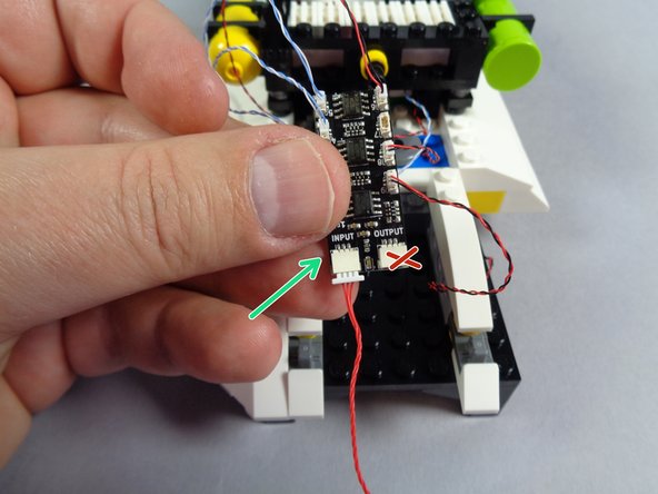 As shown in the first photo for this step, take the red 3-wire cable out of the &quot;Roof Parts&quot; bag.