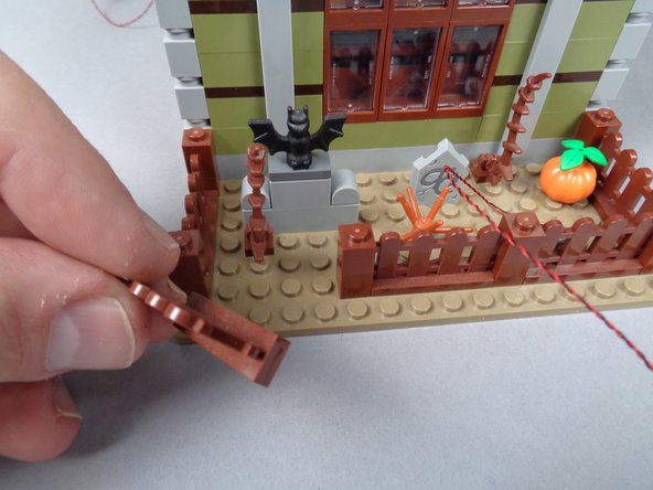 As shown in the photos for this step, remove the left front fence section and attach the second front lighting LED light so it also points toward the house.