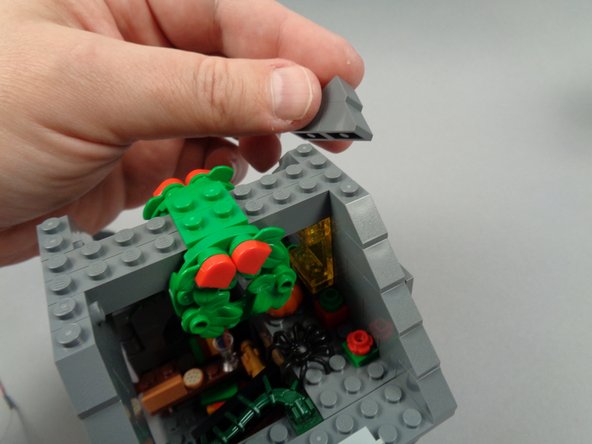 As shown in the photos for this step, remove the front and back roof slope sections above the cross-beam (the part with the wreaths), then remove the two cross-beam sections as well.