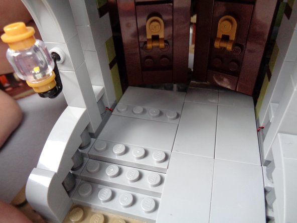 Replace the remaining pieces of the left front porch floor as shown in the second photo for this step.