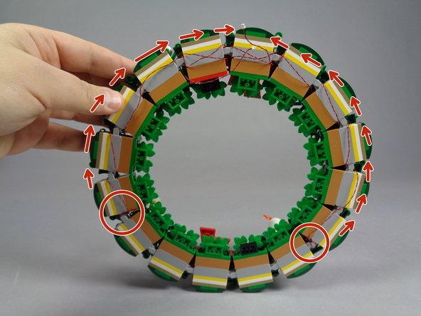 As shown by the red circles and arrows in the first photo, loop the wire for the second candle along the opposite side of the wreath using the same steps as you did for the first candle.