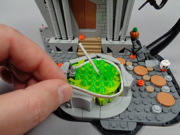 As shown by the orange rectangle in the first photo, the two studs you uncovered by removing the two transparent round plates earlier should be at the middle of the fountain.