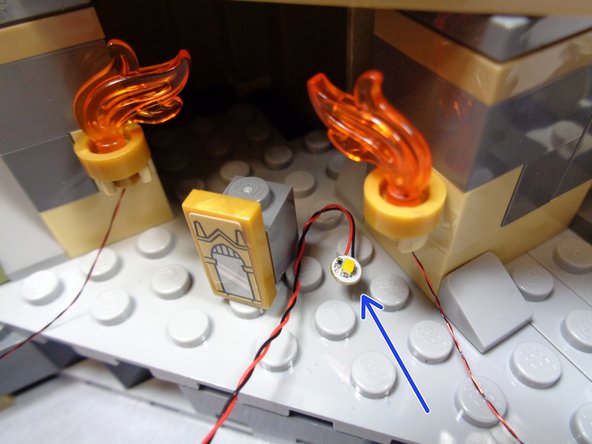 Remove two warm white lights from Bag 9 and position them between studs on the base in the Mirror of Erisred room.  The first photo shows an example of one light positioned between the four surrounding studs.