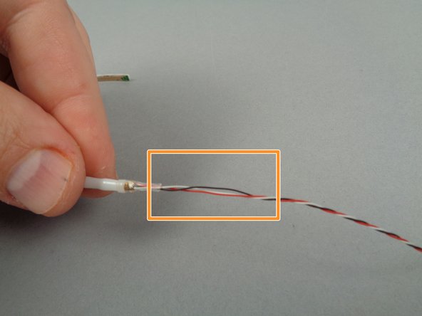 As shown by the orange box in the second photo for this step, carefully unwind the section of wire close to the end of the flexible strip.  You can do this by holding the strip with one hand and carefully turning the wire with the other hand until a small section of wire becomes un-twisted.