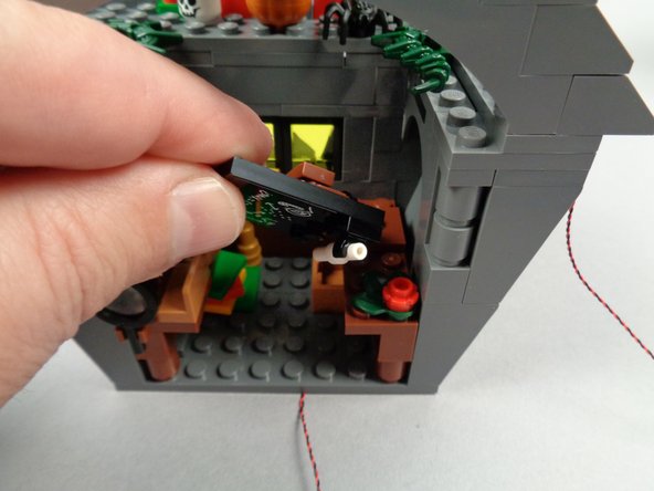 As shown in the first photo for this step, remove the blackboard assembly from Jack's house.