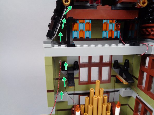 As shown in the third photo for this step, you can use the tweezers if needed to help pull both wires up into the top roof space.